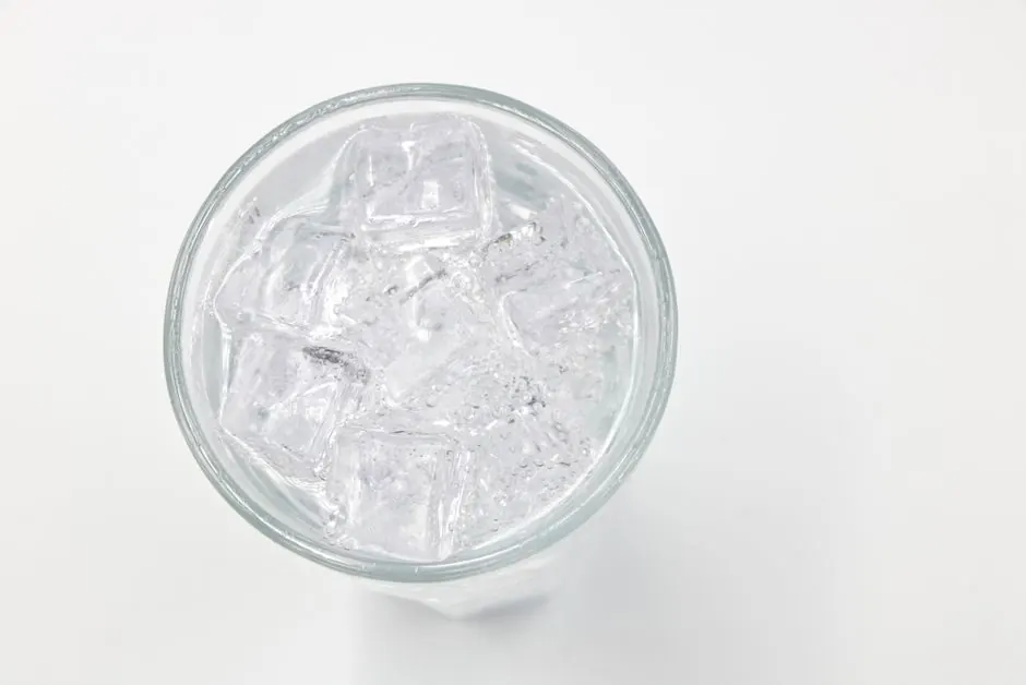 Refreshing ice cubes in a glass on a white background, perfect for drink and lifestyle themes.